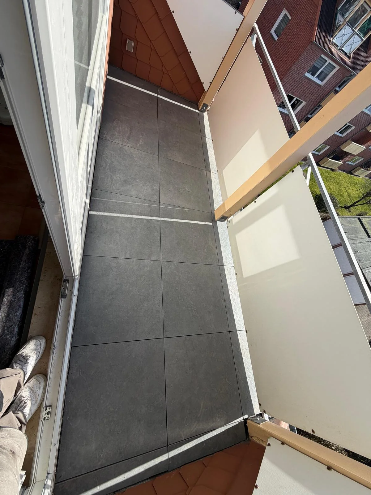 Balkon mit großformatigem grauem Bodenbelag
