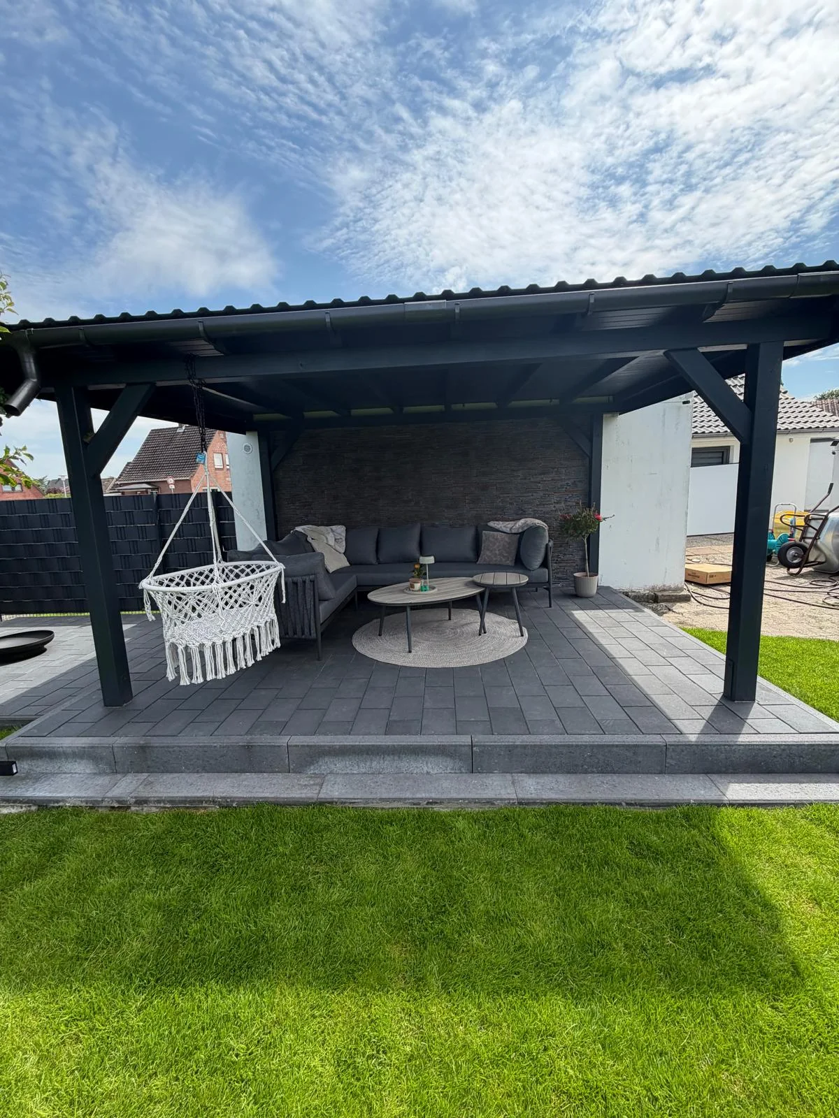 Überdachte Terrasse mit Pflasterfläche und Sitzbereich